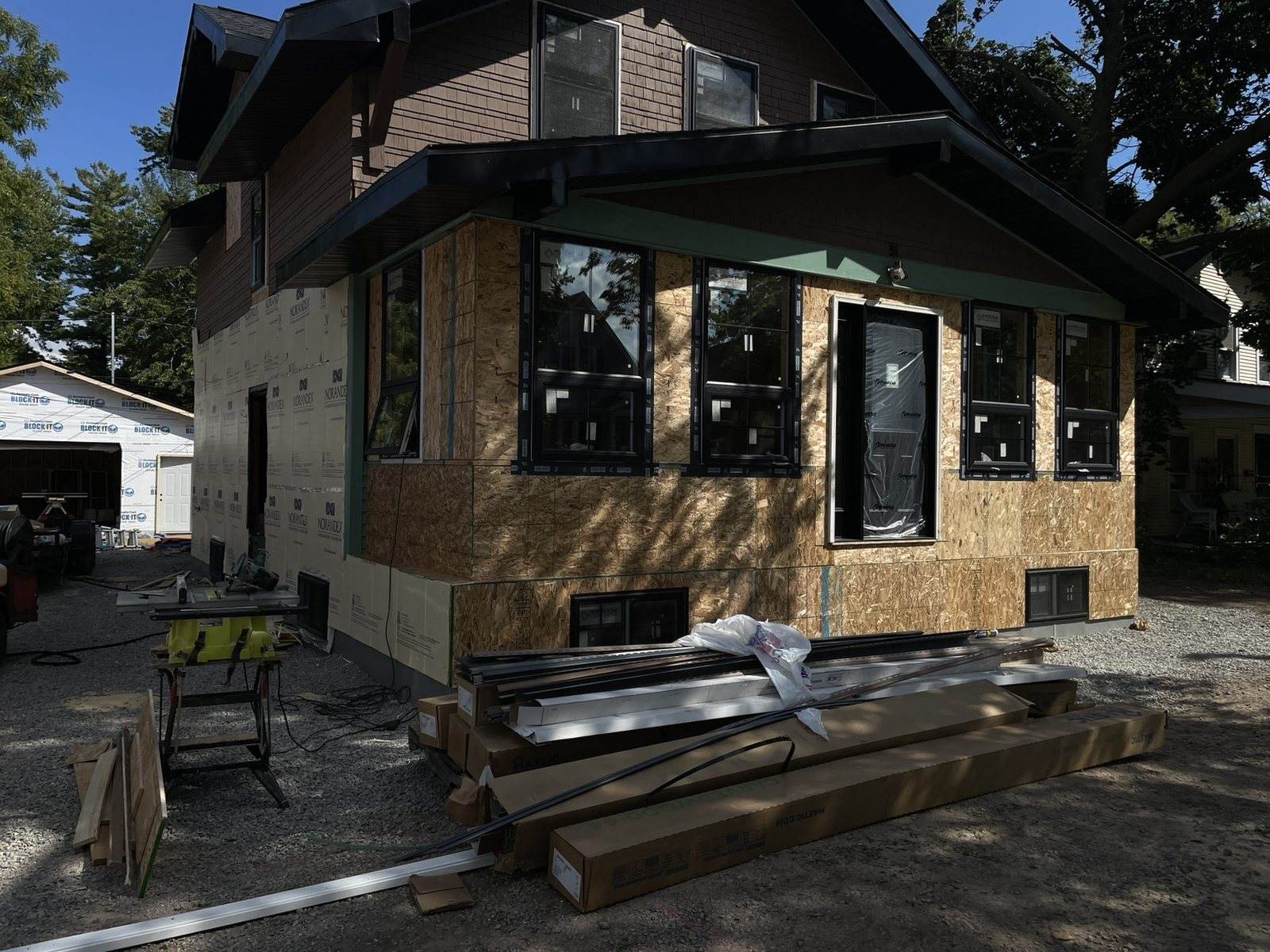 During construction: angled front view with exterior sheathing and black windows installed.