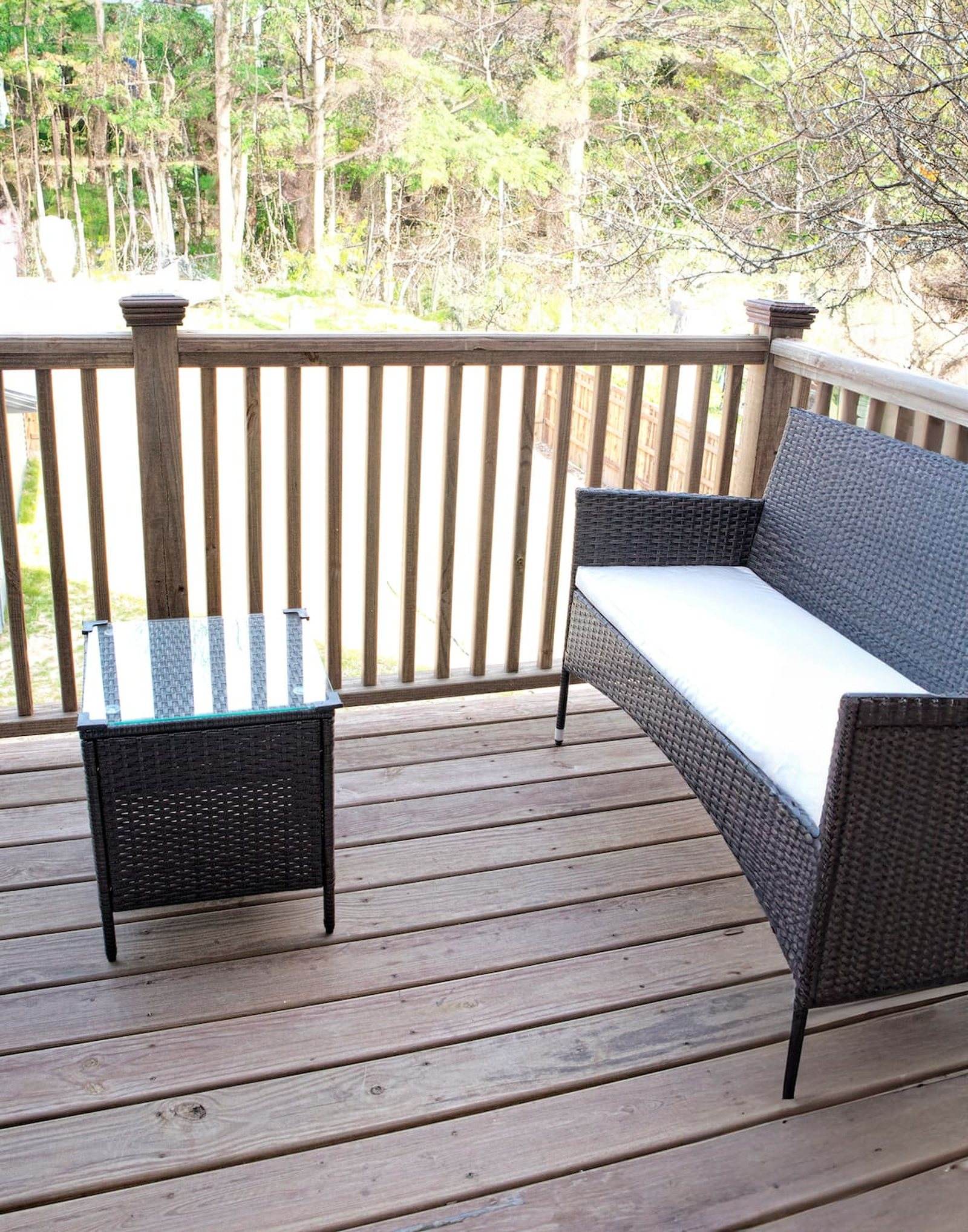 Completed upper timber balcony with woven seating and a view across the rear yard.