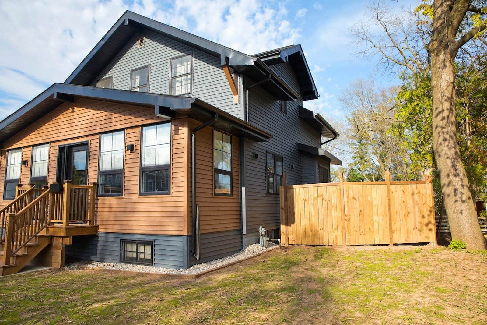 Completed Appleton residence with grey siding, timber cladding, black trim and a timber entry porch.