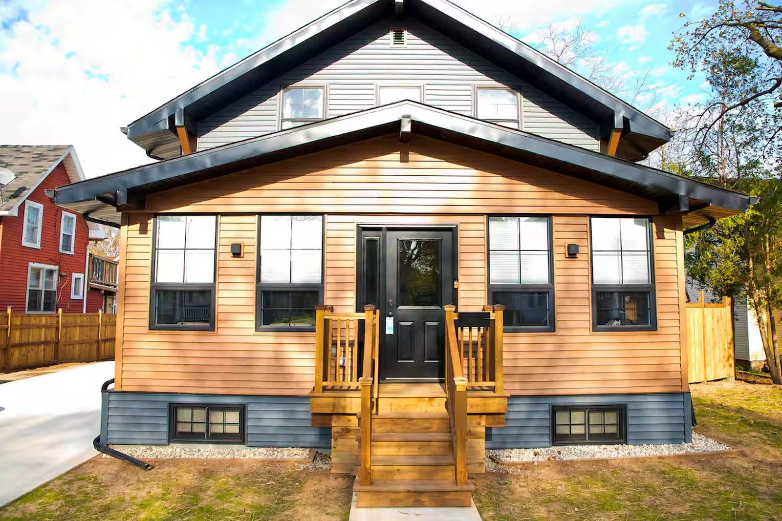 Completed Appleton home viewed straight on, with grey siding, warm timber-toned front cladding, black-framed windows and a central entry porch.