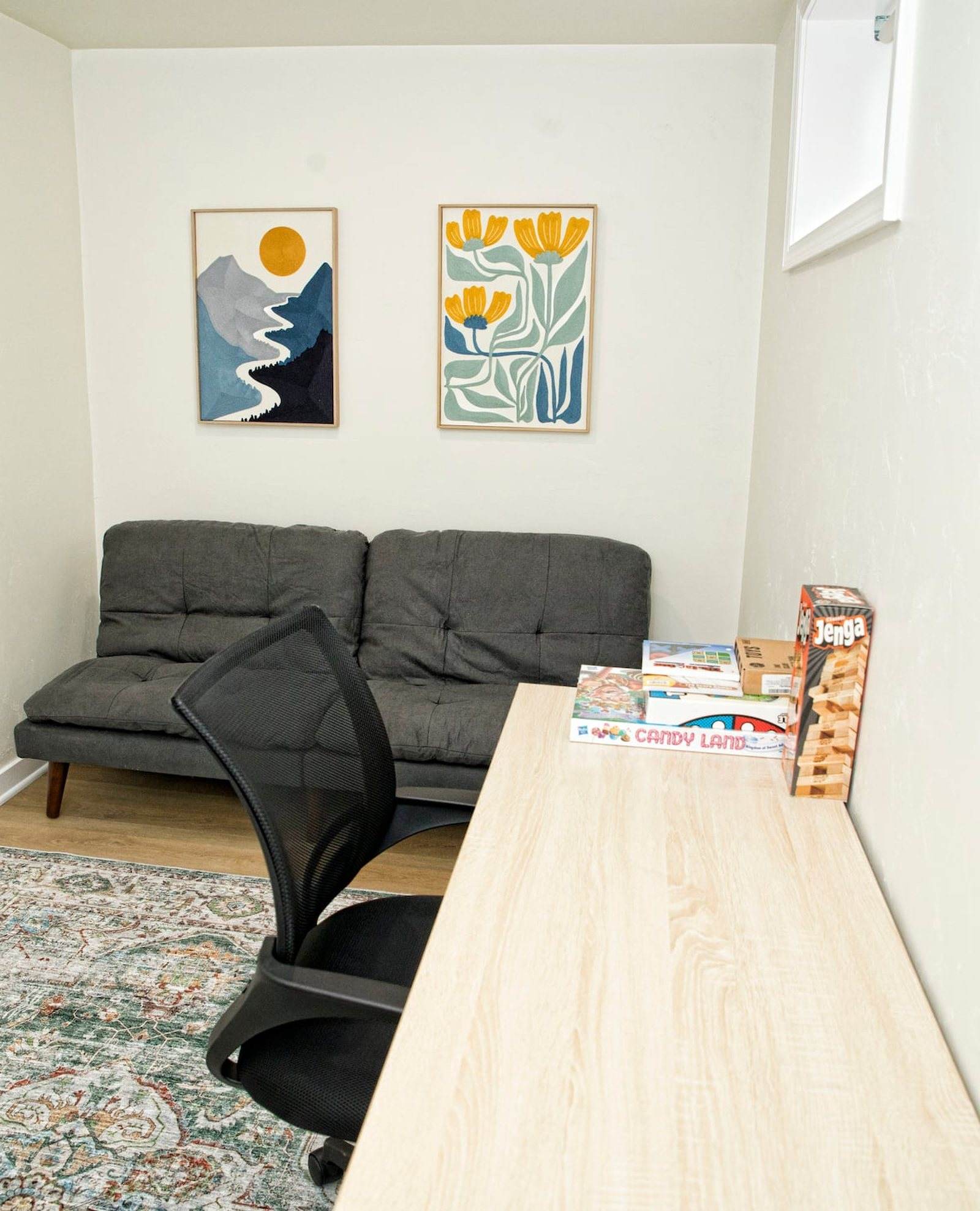 Completed office with a long timber work surface, dark seating and a patterned rug.