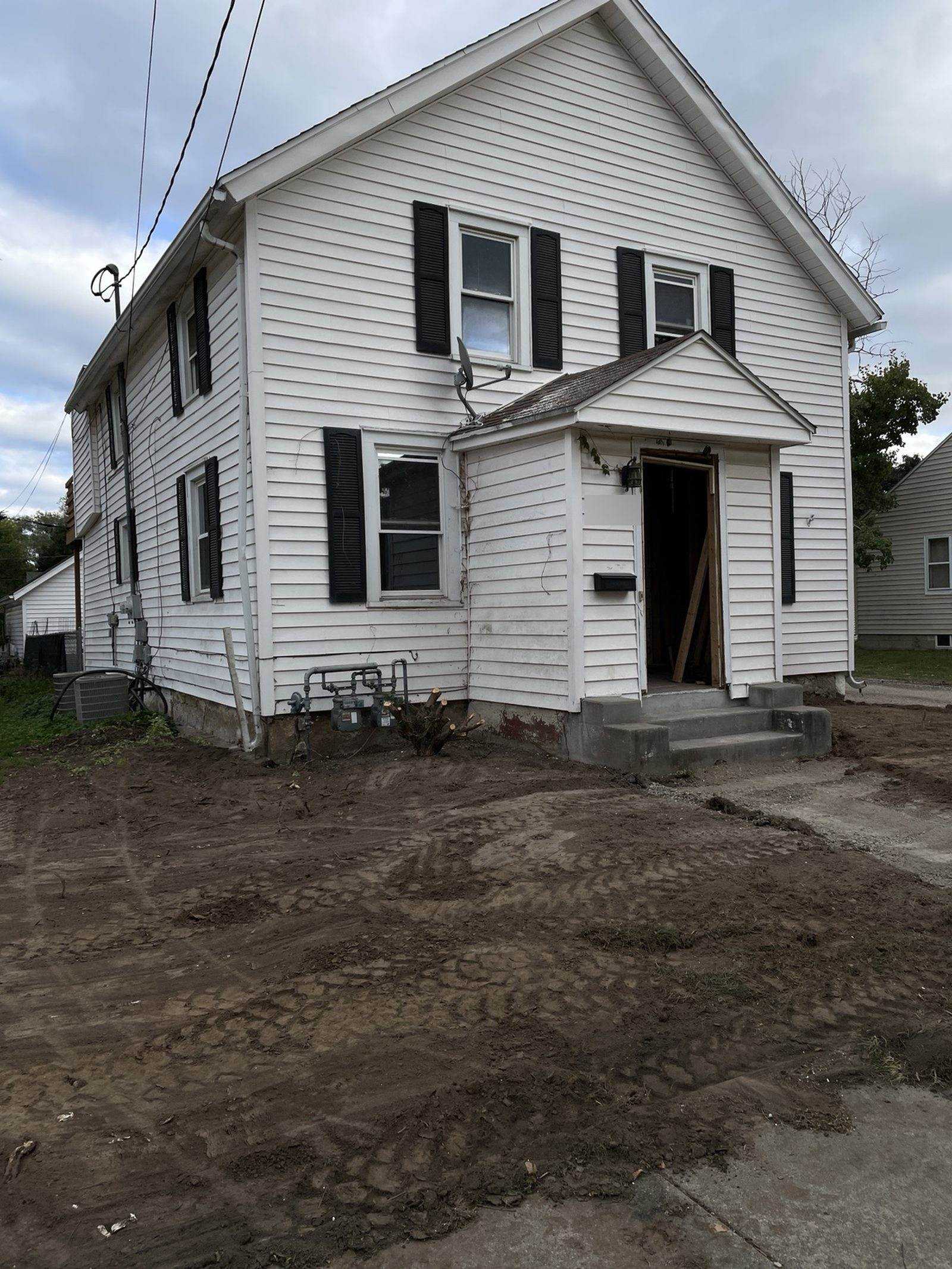 During construction: original front entrance and concrete steps after shrubs were cleared.