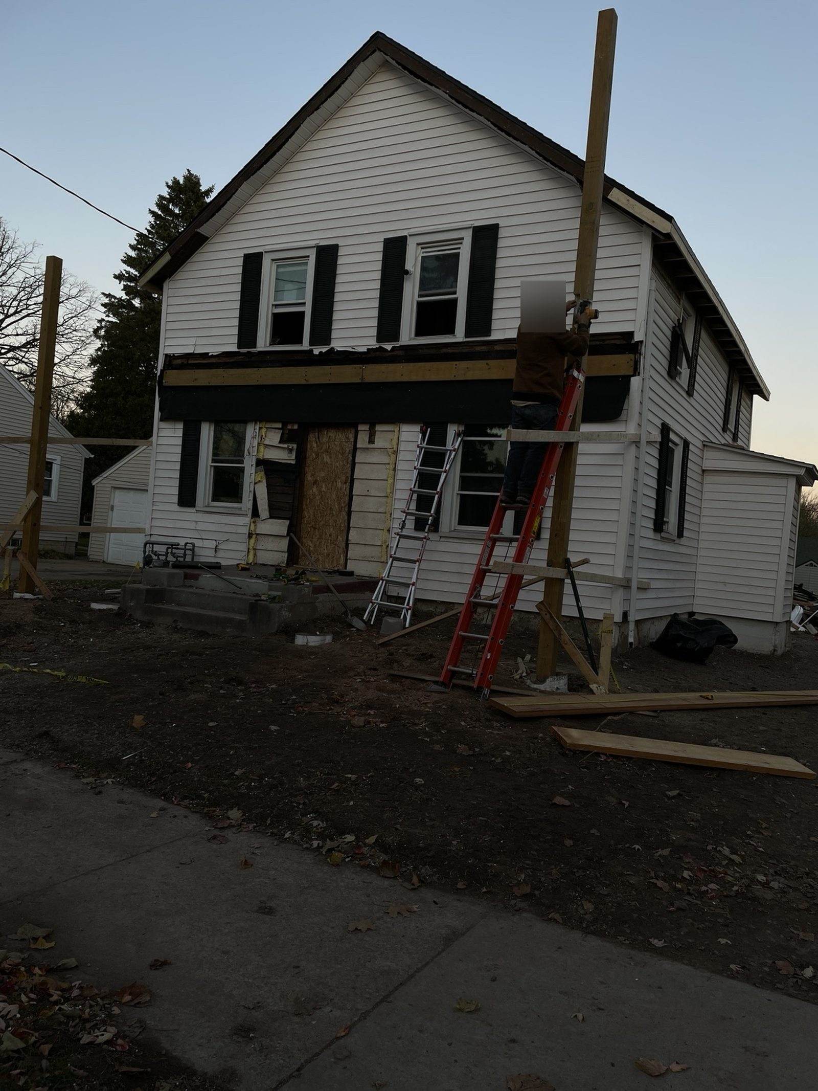 During construction: timber posts and a beam being installed across the front of the duplex.