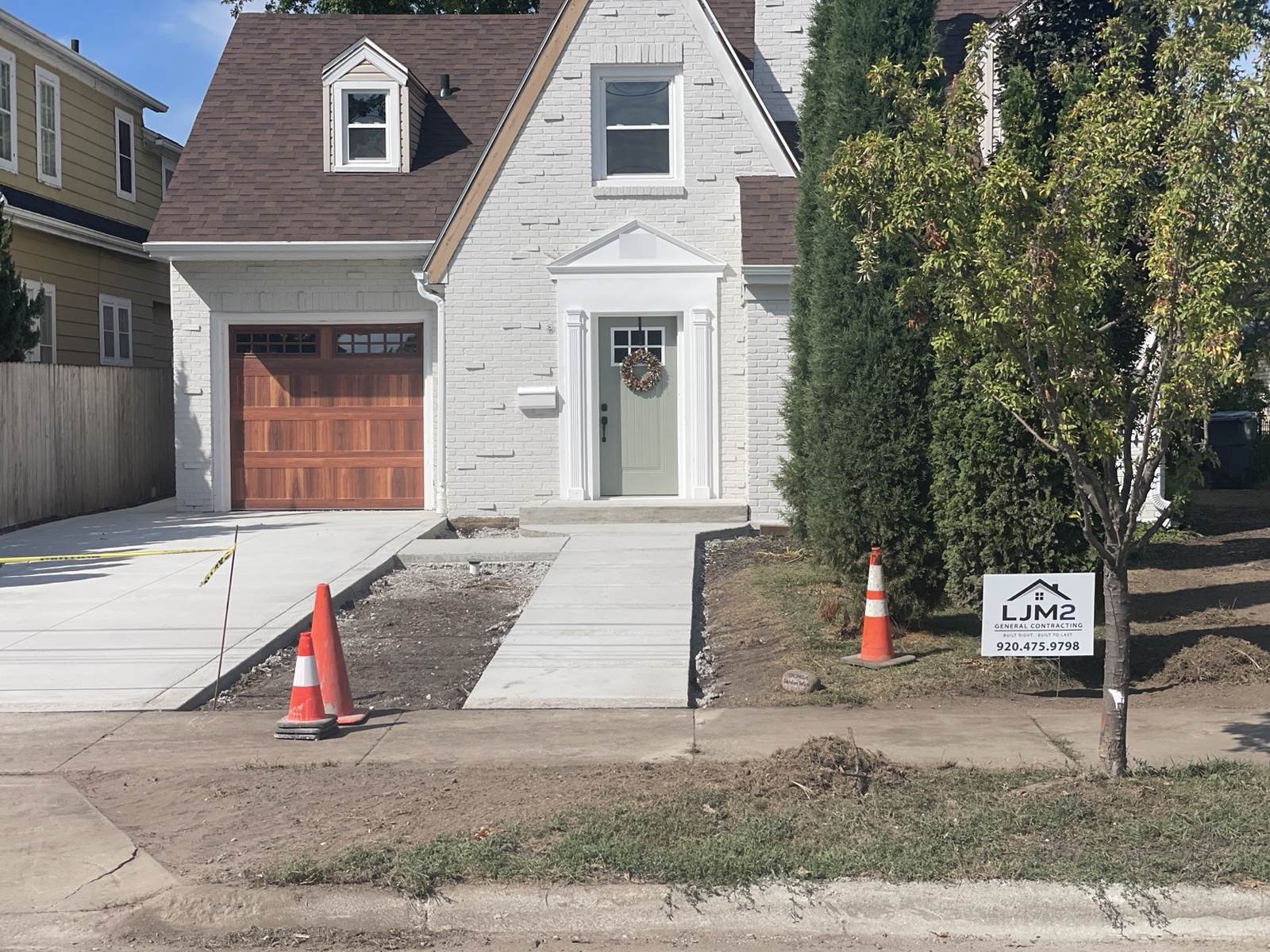 During construction: painted front exterior, timber garage door and new concrete approach before landscaping was finished.