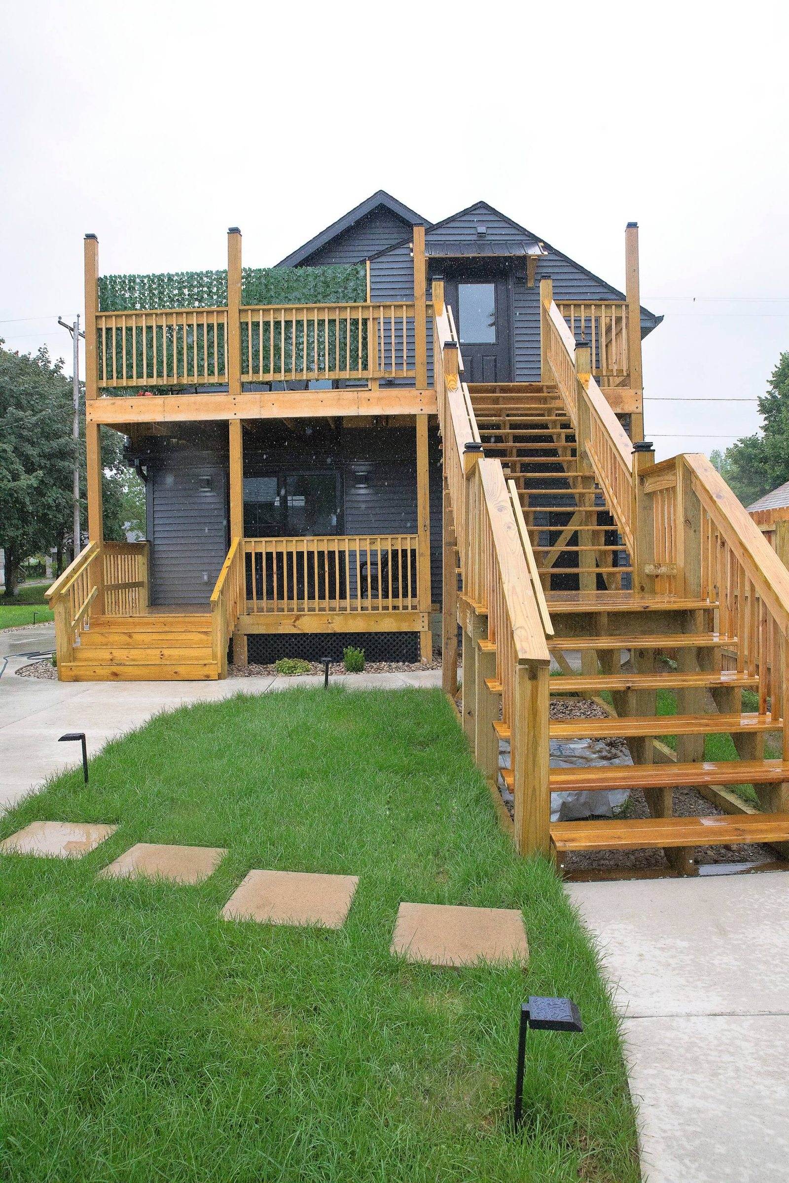 After: timber stairs and two deck levels at the rear of the duplex, with lawn and concrete paths.